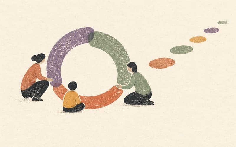 A child, carer and educator gathered around an open circle with stepping stones continuing beyond it
