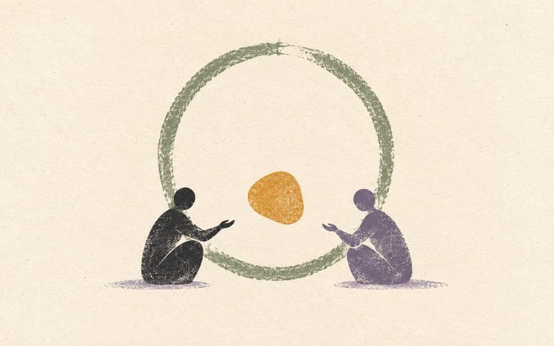 A small clinician and client facing each other inside a shared open circle